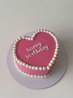 a heart shaped birthday cake with the words happy birthday written in white letters on it