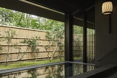 an indoor swimming pool in front of a bamboo fence