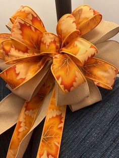 an orange and yellow bow with leaves on it