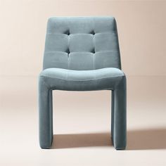 a blue chair sitting on top of a floor next to a white wall with a light colored background