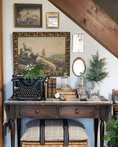 an old fashioned desk with a typewriter and pictures on the wall next to it