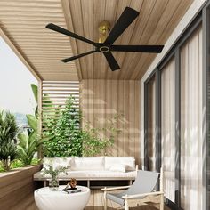 the ceiling fan is black and gold in this outdoor living room with white couches