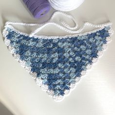 a crocheted triangle with yarn next to it