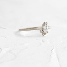 6x3mm marquise cut white diamond focal (SI1 clarity, G+ color) Three SI clarity white accent diamonds (1-2mm) Solid 14k gold setting with a delicate 1.2mm tapered round band (available in yellow, rose, and white) Total carat weight: .28ct. We handcraft each piece with responsibly sourced 14k gold and ethically sourced stones. Delicate White Gold Diamond Ring With Cubic Zirconia, Delicate Silver Moissanite Diamond Ring, Delicate White Gold Rings With Diamond Accents, Diamond White Stackable Promise Rings With Rose Cut Diamonds, White Gold Crystal Ring With Rose Cut Diamonds, Dainty Marquise Diamond Ring With Brilliant Cut, Vvs Clarity Marquise Cut Minimalist Diamond Ring, Dainty Diamond White Rings In 14k White Gold, Delicate Cubic Zirconia Diamond White Ring