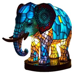 an elephant lamp is shown on a stand with its trunk extended and it's head turned to the side