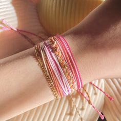 a woman's arm with bracelets on it and a plate in the background