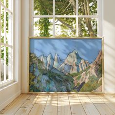 a painting on the wall in front of an open window with a view of mountains