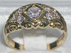 *This ring is made from 375 9K Yellow Gold with Natural TanzanitesA beautiful Victorian Style Tanzanite Ring set with a centre 4.5mm (0.18" inches) and six 2.25mm (0.09" inches)  Tanzanites set in a gorgeous 9ct Gold setting. PLEASE MAKE SURE YOU STATE THE FINGER SIZE YOU REQUIRE WITH YOUR PAYMENT.Completely made from Solid English 9K Gold Hallmarked by the London Assay Office which confirms the rings authenticity. The Hallmark includes the 375 marking for 9K Gold. This is a delightful piece to Pink And Gold Rings, Heirloom Amethyst Ring With Diamond In Gold, Heirloom Gold Amethyst Ring With Diamond, Heirloom Gold Amethyst Ring With Rose Cut Diamonds, Gold Amethyst Ring With Brilliant Cut For Wedding, Formal Gold Amethyst Ring With Rose Cut Diamonds, Gold Amethyst Ring With Rose Cut Diamonds For Anniversary, Formal Rose Cut Amethyst Ring In Yellow Gold, Gold Brilliant Cut Amethyst Ring For Wedding