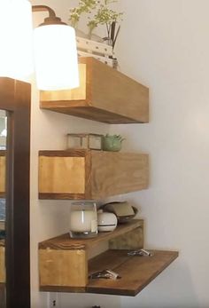 a bathroom with wooden shelving on the wall next to a sink and toilet paper dispenser