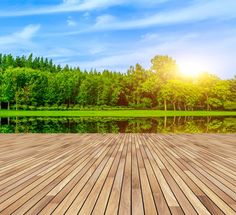 an empty wooden deck overlooking a lake and forest