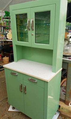 a green cabinet sitting on top of a wooden floor