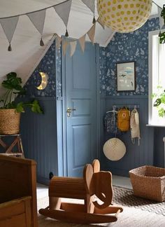 a child's room with blue walls and wooden furniture