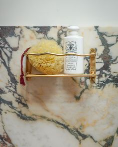 a marble counter top with soap, lotion and scrubs on the shelf next to it