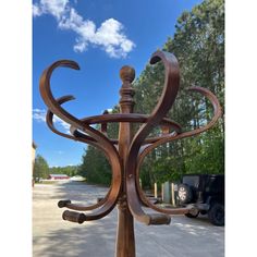 a wooden sculpture is sitting in the middle of a parking lot