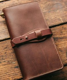 a brown leather journal sitting on top of a wooden table