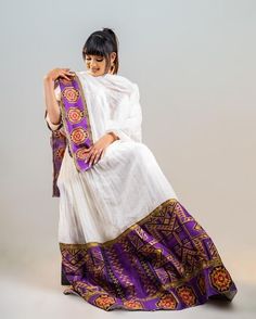 This full Shimena Kemis is a true celebration of Ethiopian culture and tradition. The dress is made with high-quality Menen fabric, which adds a touch of elegance and sophistication to the overall design. The dress features vibrant colors that are inspired by the Ethiopian landscape and culture. The dress is designed to fit comfortably and flatteringly, with a fitted bodice and a full skirt that flows beautifully as you move. The dress is complemented by carefully selected accessories, such as a Habesha Dress Modern, Ethiopian Landscape, Eritrean Dress, Ethiopian Culture, Habesha Dress, Ethiopian Traditional Dress, Casual Beach Sandals, Ethiopian Dress, Habesha Kemis