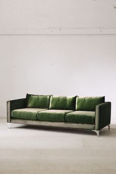 a green couch sitting on top of a white floor