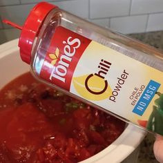 a person is pouring sauce into a bowl with food in the bottom and on top