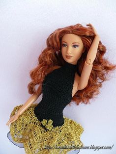 a doll with red hair wearing a black dress