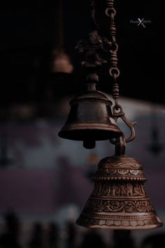 a bell hanging from a chain in the dark