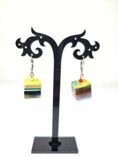 These earrings are part of the Pop Art line and are called Popinho Medio. The Pop Art line was created by Sobral to represent the passage of Modernity into Post Modernity in the Western culture. These earrings are the Day version and feature a multicolor striped dangling cube. They measure 1 3/8" in total length and the diameter of the cube 5/8". I also have necklaces, bracelets and rings available in this pattern. The first United Nations Conference to address environmental degradation was held in Stockholm in 1972. Already at that time the designer Carlos Sobral was working with resin and creating new techniques and alternative products to reuse all the raw material he consumed in the production of his collections. All Sobral production strictly follows the current environmental standard Colorful Drop Earrings As A Gift, Handmade Multicolor Earrings For Gift, Handmade Multicolor Earrings As Gift, Adjustable Rainbow Earrings As Gift, Unique Rainbow Earrings, Artistic Handmade Rectangular Earrings, Artisan Earrings With Artistic Design For Gift, Handmade Artistic Rectangular Earrings, Artisan Earrings With Artistic Design As A Gift