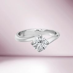 a white gold ring with a single diamond in the center on a light pink background