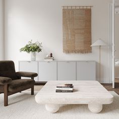 a living room with a white coffee table and two brown chairs in front of it