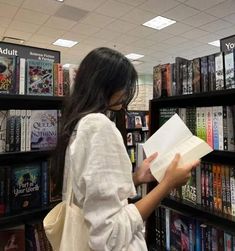 a woman reading a book in a library