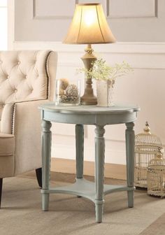 a small table with a lamp on it next to a chair and a birdcage