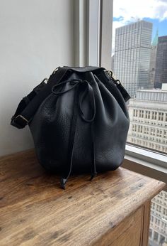 "For more handmade leather bags, purses, satchels, messengers, travel bags, holdalls, carry alls, handbags, shoulder bags, click here: http://etsy.me/1muiXbL. Large size bucket bag is made out of soft black bison leather and soft black leather strap. Its easily opens and closes with the leather drawstring, it expansionists and minimizes very easily and turns a purse into a weekender. Our bucket bag comes with an adjustable and removable leather strap, brass hardware and large hanging pocket. Mad Bison Leather, Soft Leather Handbags, Black Leather Crossbody Bag, Leather Notebook, Handbag Black, Black Leather Handbags, Leather Bucket Bag, Leather Bucket, Leather Bags Handmade