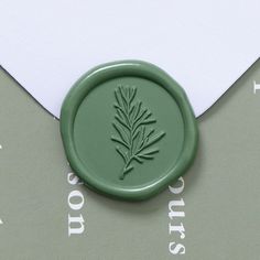 a wax stamp with a green leaf on it