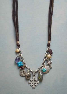 a necklace with charms and beads hanging from it's side on a gray surface