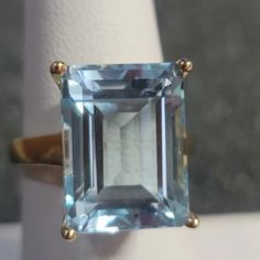 R167 $269 Aquamarine Cocktail Ring Size 7 14.50ct Aquamarine Emerald Cut Diamond Cocktail Or Engagement Ring 14k Yellow Gold Over 925 Sterling Silver Beautiful Bold Aquamarine Ring. All Weights And Measurements Are Approximate. Elegant Emerald Cut Blue Gemstones, Elegant Blue Emerald Cut Gemstones, Fine Jewelry Topaz Ring For Formal Occasions, Classic Aquamarine Rings For Formal Occasions, Classic Aquamarine Gemstone Jewelry, Blue Solitaire Emerald Ring In Classic Style, Classic Blue Emerald Ring With Accent Stones, Blue Solitaire Emerald Ring Classic Style, Formal Blue Emerald Ring With Accent Stones