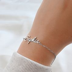 This beautiful bracelet features a custom name charm made from silver and 18k gold PVD plated stainless steel and 9 different chain types to choose from. Available in lengths of 6 to 8 inches. A lovely gift or a special treat for yourself! Font type in photos: Amelia: Font 2 Sophia: Font 1 Material: Stainless Steel Chain Types: Figaro                         Rolo (2mm)                         Medium Paperclip (3.5x12mm)                         Curb (2 mm)                         Satellite Sterling Silver Name Bracelet Jewelry, Minimalist Sterling Silver Name Bracelet For Personalized Gift, Minimalist Sterling Silver Name Bracelet As Personalized Gift, Customizable Sterling Silver Name Bracelet Gift, Dainty Sterling Silver Custom Name Bracelet, Personalized Adjustable Signature Jewelry, Classic Name Bracelet As A Gift, Sterling Silver Nameplate Bracelet For Gift, Sterling Silver Nameplate Bracelet As Gift