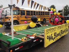 a school bus trailer with balloons and decorations on the flatbed, parked in a parking lot