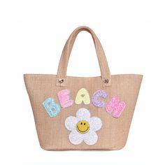 Front view of straw 'Beach' tote bag with glitter daisy and bubble-letter patches Beachy Sand Straw Bag For Beach Season, Sand Color Straw Bag For Beach Season, Trendy Beige Beach Bag For Beach Season, Trendy Beige Beach Bag, Summer Sand-colored Tote Beach Bag, Trendy Straw Bag With Braided Handles For Vacation, Trendy Top Handle Beach Shoulder Bag, Chic Double Handle Beach Bag, Trendy Crochet Top Handle Bag For Beach