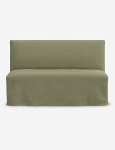 a green couch with a long arm and two pillows on the back, in front of a white background