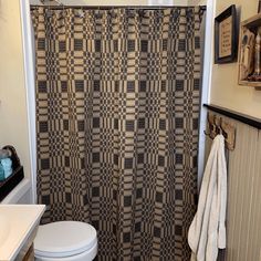 a bathroom with a checkered shower curtain next to a toilet