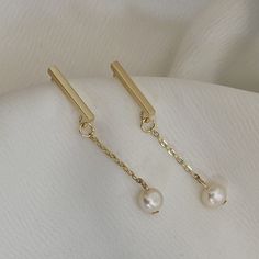 This pair of earrings showcases a classy and elegant pearl dangling from a classy long bar stud. It can elevate any outfit, casual or fancy. The earrings are made using high quality gold plated metal and real freshwater pearls. It makes an ideal gift for family, friends and yourself. Bar Studs, Gold Bar, Crystal Charm, Gifts For Family, Ideal Gift, Fresh Water, Freshwater Pearls, Jewelry Earrings Dangle, Etsy Earrings