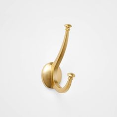 a gold hook on a white wall