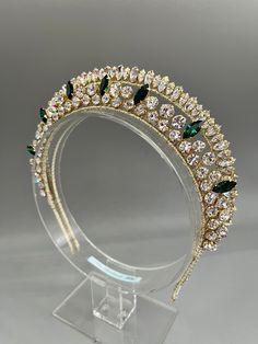 a gold tiara with green and white stones on it's headpieces