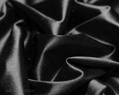 black silk fabric textured with small dots on the top and bottom, closeup