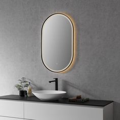 a bathroom vanity with a round mirror above it and a sink under the countertop