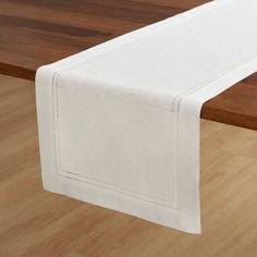 a white table runner on top of a wooden table