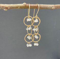 "14k Solid Gold Herkimer Diamond Dangle Earrings.  These playful solid gold dangle earrings have a waterfall of Herkimer Diamonds tumbling through three irregular shaped 14k gold hoops. Herkimer diamonds are double-terminated quartz crystals - they have a lovely sparkle that plays off the swiveling gold hoops and glint as they catch and reflect the light.  They are 14k solid gold and measure 2.25\" long by 0.5\" wide. They are handmade to order.  All designs come in a box ready for gifting." Modern Gold Briolette Earrings, Anniversary Yellow Gold Linear Earrings With Ear Wire, 14k Gold Long Drop Linear Earrings For Anniversary, Yellow Gold Dangle Cluster Earrings For Anniversary, Yellow Gold Diamond Cut Linear Earrings For Anniversary, Gold Dangle Cluster Earrings Fine Jewelry, 14k Gold Dangle Linear Earrings For Anniversary, Everyday Diamond Cut Drop Earrings, Gold Briolette Single Earring