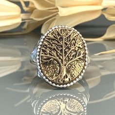 "Oval Two Tone Tree of Life Metal Alloy Bead, Sterling Silver, Yellow or Rose Gold Filled Wire Wrapped Ring; Custom Made to Size This Two Tone Tree of Life Wire Wrapped Ring is a unique and meaningful gift for nature lovers. The Tree of Life symbolizes growth, strength, and interconnectedness, making it a powerful symbol to wear as a daily reminder. Handcrafted in your choice of wire type for the band and an alloy bead, this ring is a perfect addition to any jewelry collection. The customizable Tree Of Life Wire, Tree Of Life Ring, Life Ring, Wire Wrapped Ring, Wire Wrapped Rings, Argentium Silver, Beads And Wire, Wrap Rings, Gifts For Nature Lovers