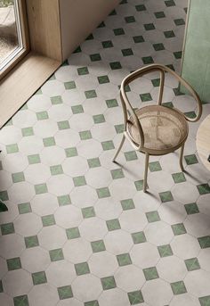 a chair sitting in front of a window next to a tiled floor with green squares on it