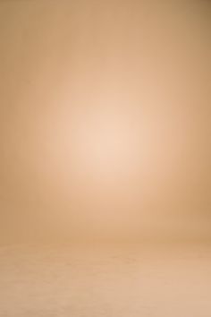 an orange and white vase sitting on top of a table next to a brown wall