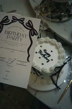 a birthday party with a white cake and black writing on the paper that says happy birthday