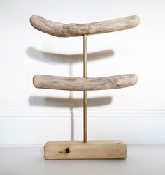 a wooden stand with three pieces of driftwood on it's sides and one piece of wood sticking out of the top